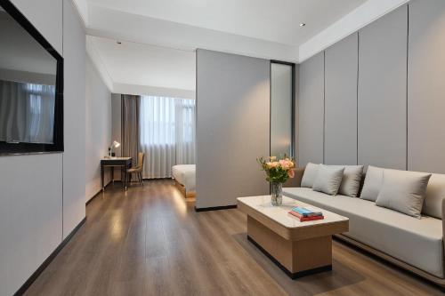 a living room with a couch and a table at Urbain S Hotel, Xiamen Railway Station Mingfa Commercial Plaza in Xiamen