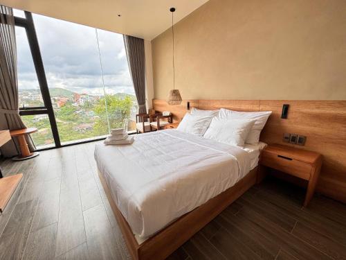 a bedroom with a large bed with a large window at Là Yên Villa - Đà Lạt in Ấp Ða Lợi