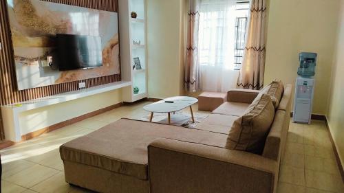 a living room with a couch and a table at Mayree Homes in Langata Rongai