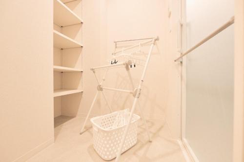 a white laundry room with a basket and shelves at ReLA Higashimatsudo - Vacation STAY 66379v in Matsudo