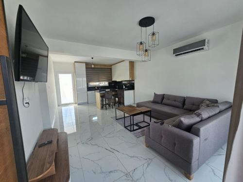 ein Wohnzimmer mit Sofa und Fernseher in der Unterkunft Luxury Apartment at Four Seasons Life 2 14-B in Vokolidha