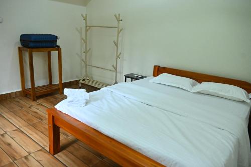 a bedroom with a large bed with white sheets at Anugraha Bed&Breakfast Homestay in Kumta