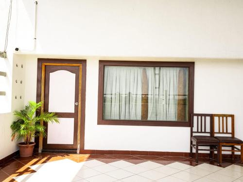 a room with a door and a chair and a window at Eastin Park in Navalur