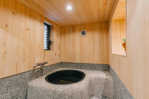 a bathroom with a stone sink in a wooden wall at Hotaru no Yado - Vacation STAY 68063v in Fukuyama