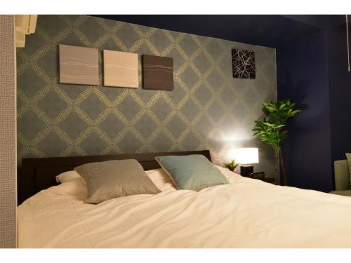 a bedroom with a bed with two pillows on it at Alphabed Takamatsu Furujinmachi - Vacation STAY 11905 in Takamatsu