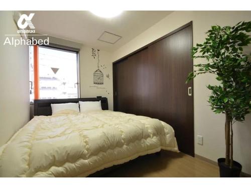 ein Schlafzimmer mit einem großen Bett mit einem hölzernen Kopfteil in der Unterkunft Alphabed Takamatsu Hyogomachi - Vacation STAY 11902 in Takamatsu