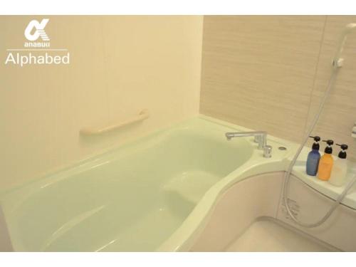 eine weiße Badewanne im Bad mit Dusche in der Unterkunft Alphabed Takamatsu Hyogomachi - Vacation STAY 11902 in Takamatsu