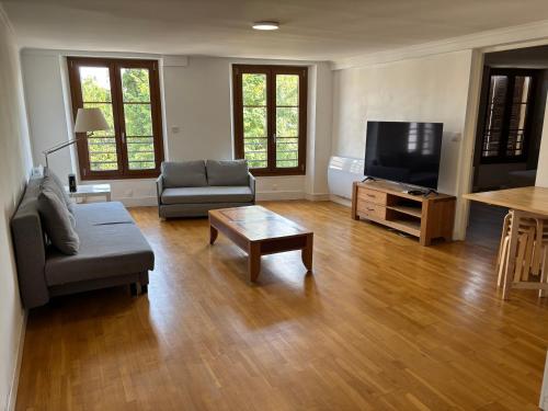 a living room with a couch and a flat screen tv at Appart 15min Paris Versailles 20min Orly in Bièvres