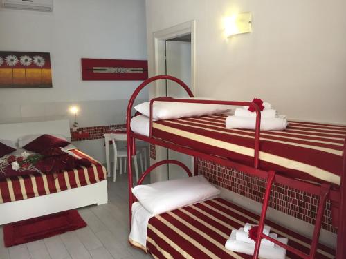 a room with two bunk beds and a table at Rosa di Ortigia in Syracuse