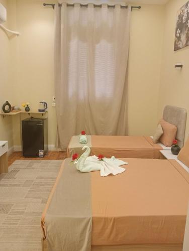 a hotel room with two beds with towels on them at Tahrir Palace in Cairo