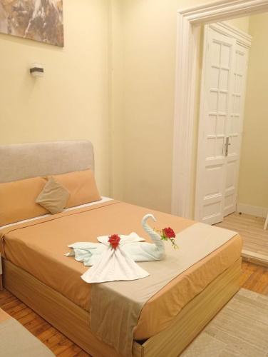 a bedroom with a bed with flowers and a swan on it at Tahrir Palace in Cairo