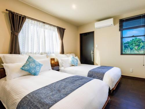 a hotel room with two beds and a window at Grace Villa Miyakojima - Vacation STAY 58441v in Uechi