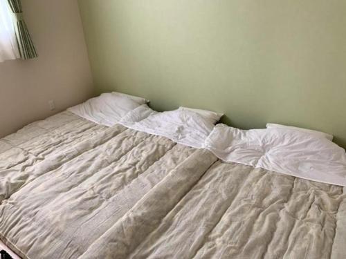 an unmade bed in a corner of a bedroom at Kawaguchiko Villa FJ Resort - Vacation STAY 63288v in Fujikawaguchiko