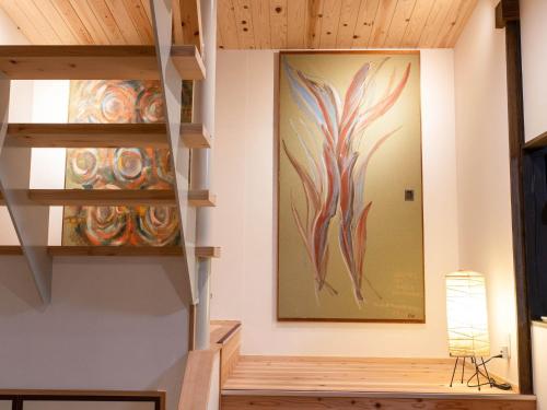 a staircase in a room with a painting on the wall at Takayanagi Ryokan - Vacation STAY 88528v in Takamatsu