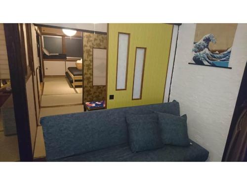 淡路市にあるAWAJISHIMA KOMINKA NO YADO - Vacation STAY 12108の青いソファと鏡のあるリビングルーム