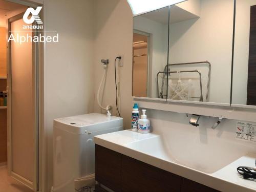 a bathroom with a toilet and a sink and a mirror at Alphabed Takamatsu Furujinmachi - Vacation STAY 11907 in Takamatsu