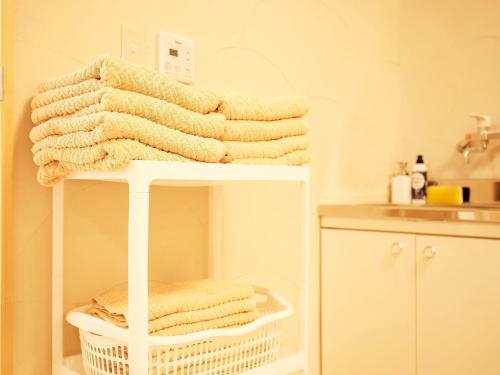 a pile of towels on a shelf in a bathroom at Mcity in Maejima - Vacation STAY 54881v in Naha