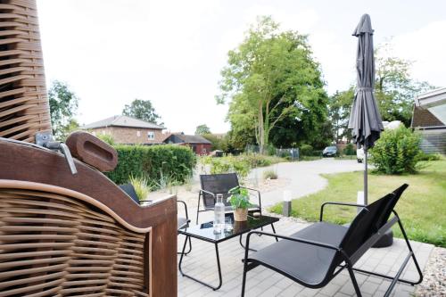a patio with a table and chairs and an umbrella at Kleines Küstennest in Grömitz
