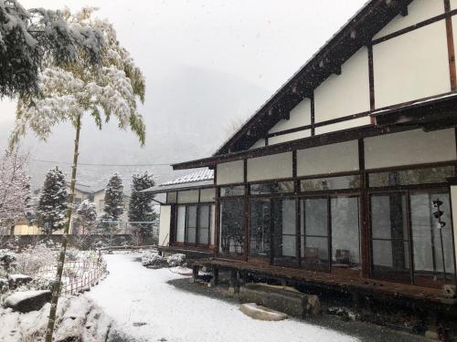 a building with snow on the ground next to a tree at Fukurou no Oyado - Vacation STAY 71438v in Fuefuki