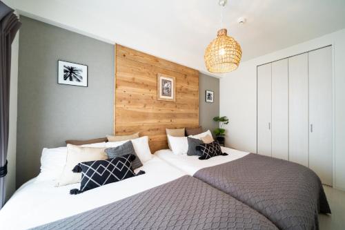 a bedroom with a large bed with a wooden headboard at Vent du Vent 402 - Vacation STAY 83691v in Urasoe