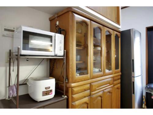 a wooden cabinet with a microwave in a kitchen at NYOZE House - Vacation STAY 84305v in Tokyo