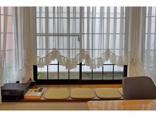 a window with white curtains and a desk with a printer at NYOZE House - Vacation STAY 84305v in Tokyo