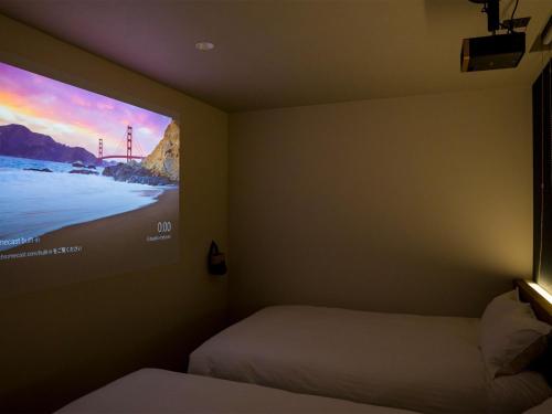 a room with two beds and a tv on the wall at Rakuten STAY Fuji Kawaguchiko Station - Japanese Modern Villa Mt Fuji View 105 in Fujikawaguchiko