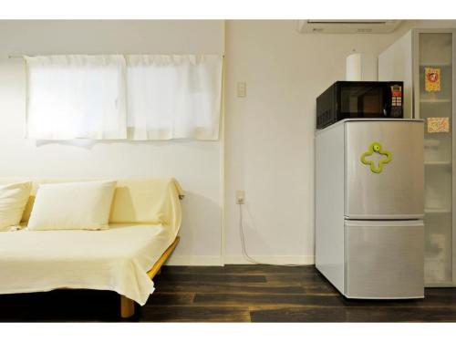 a room with a bed and a small refrigerator at Konpeitou House - Vacation STAY 11969 in Osaka