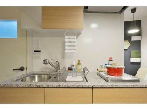 a kitchen with a sink and a counter top at Konpeitou House - Vacation STAY 11969 in Osaka
