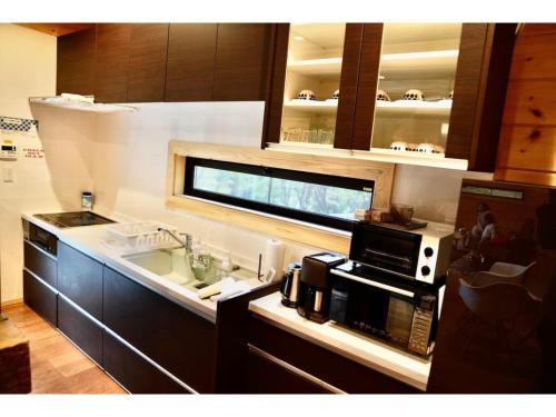 eine Küche mit Spüle und Mikrowelle in der Unterkunft Polar Haus MinamiKaruisawa1 - Vacation STAY 88000v in Karuizawa