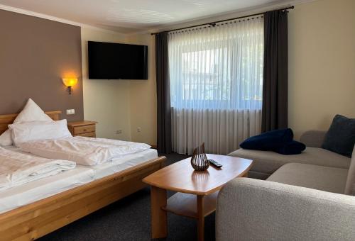 a hotel room with a bed and a couch at Pension Leithenwald in Zwiesel