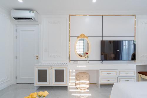 a white kitchen with a table and a mirror at DT Retreat - Biệt thự nguyên căn - 3 Phòng ngủ - Novaworld Phan Thiết in Phan Thiet