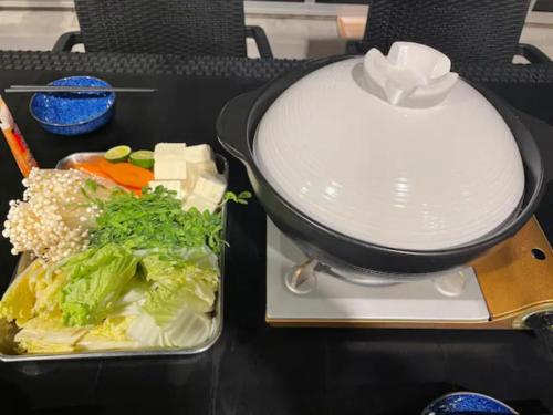 a lunch box with vegetables and a lid on a table at Palm Villa - Vacation STAY 12202 in Takamatsu