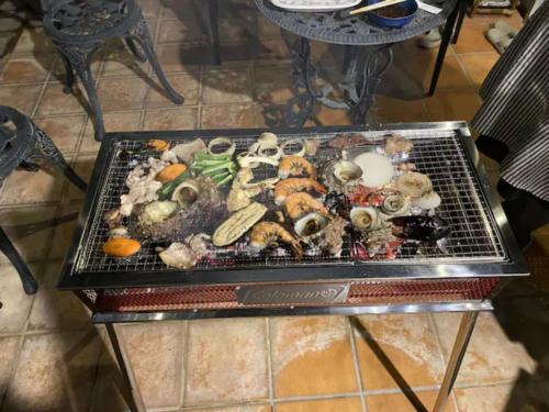 a grill full of different types of seafood and vegetables at Palm Villa - Vacation STAY 12202 in Takamatsu