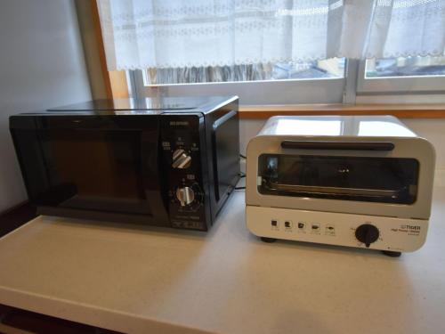 a microwave and a toaster oven on a counter at Palm Villa - Vacation STAY 12202 in Takamatsu