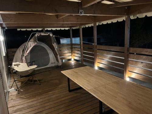 a tent on a deck with a wooden table at Kikuya Cottage CREA - Vacation STAY 92198v in Yamanakako