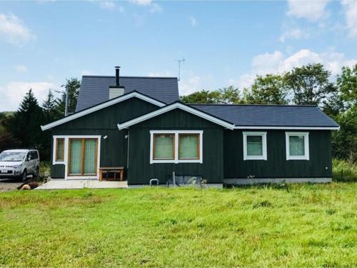 a green house with a van parked in a yard at Farm Inn Torch B - Vacation STAY 92724v in Tsurui