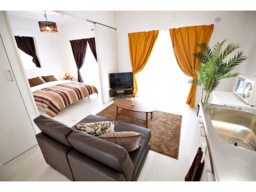 a living room with a couch and a bed and a sink at Vent du Vent - Vacation STAY 83347v in Urasoe