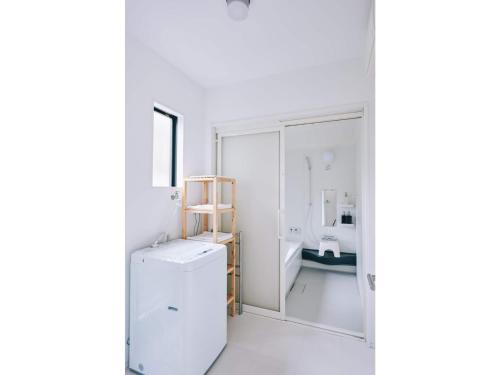 ein weißes Badezimmer mit Kühlschrank und Waschbecken in der Unterkunft Capetown Resort - Vacation STAY 96524v in Isumi