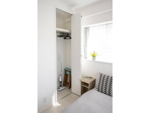 a bedroom with a bed and a window at Vent du Vent 5F - Vacation STAY 83698v in Urasoe
