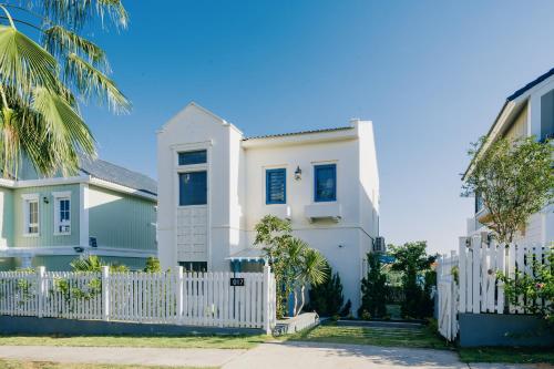 a white house with a white picket fence at DT Retreat - Biệt thự nguyên căn - 3 Phòng ngủ - Novaworld Phan Thiết in Phan Thiet