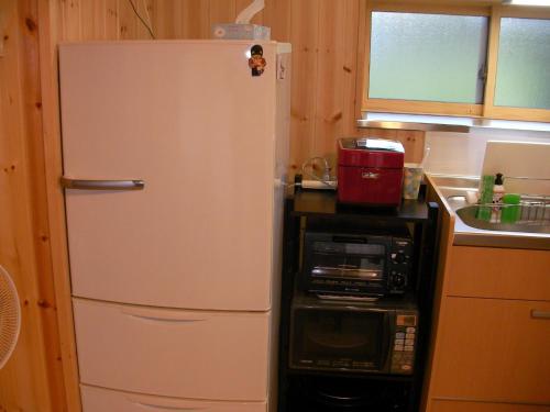 a white refrigerator in a kitchen with a microwave at Gujo Cottage Ryukobashi no Hotori - Vacation STAY 88697v in Gujo