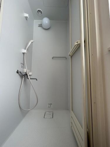 a shower in a white bathroom with a showeriterator at niseko kamahale village - Vacation STAY 85808v in Kaributo