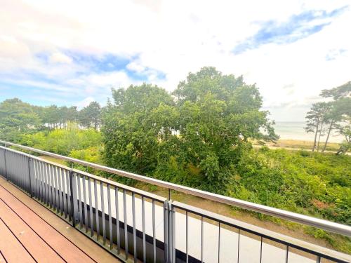 a balcony of a house with a view of trees at Ferienwohnung Meerblick in Juliusruh