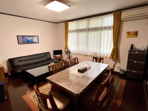 a living room with a table and chairs and a couch at Mitsuba House- Vacation STAY 12196 in Annaka
