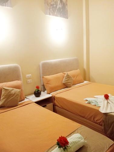 a hotel room with two beds with flowers on them at Tahrir Palace in Cairo