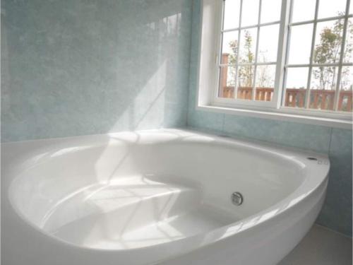 W łazience z oknem znajduje się biała wanna. w obiekcie Polar House NishiKaruisawa1 - Vacation STAY 00251v w mieście Oiwake