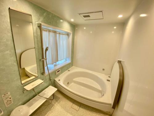 a bathroom with a tub and a toilet and a sink at Polar House ShinKaruisawa1 - Vacation STAY 00271v in Karuizawa