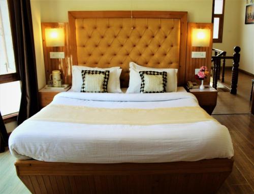 a bedroom with a large bed with a large headboard at Hotel Golf Links, Mashobra in Mashobra
