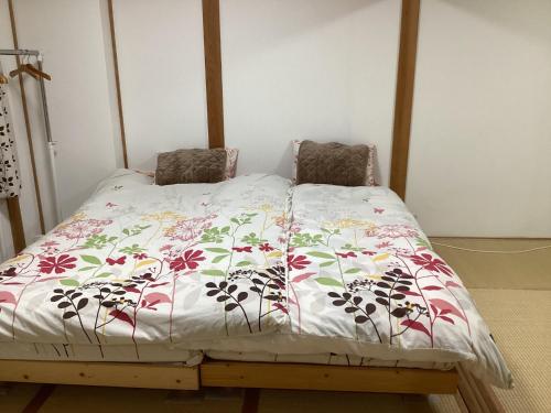a bed with a white comforter with flowers on it at Osaka and house - Vacation STAY 16309 in Osaka